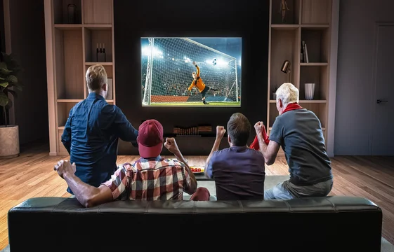 A group of people are excitedly enjoying watching a football match on TV through IPTV subscription technology