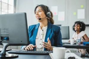 Two women working on customer service calls in an office setting, representing the Contact Us page