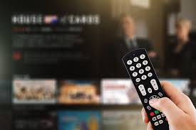 "The image displays a hand holding a TV remote control, which appears to be in use for accessing IPTV technology and its associated TV channels and content."